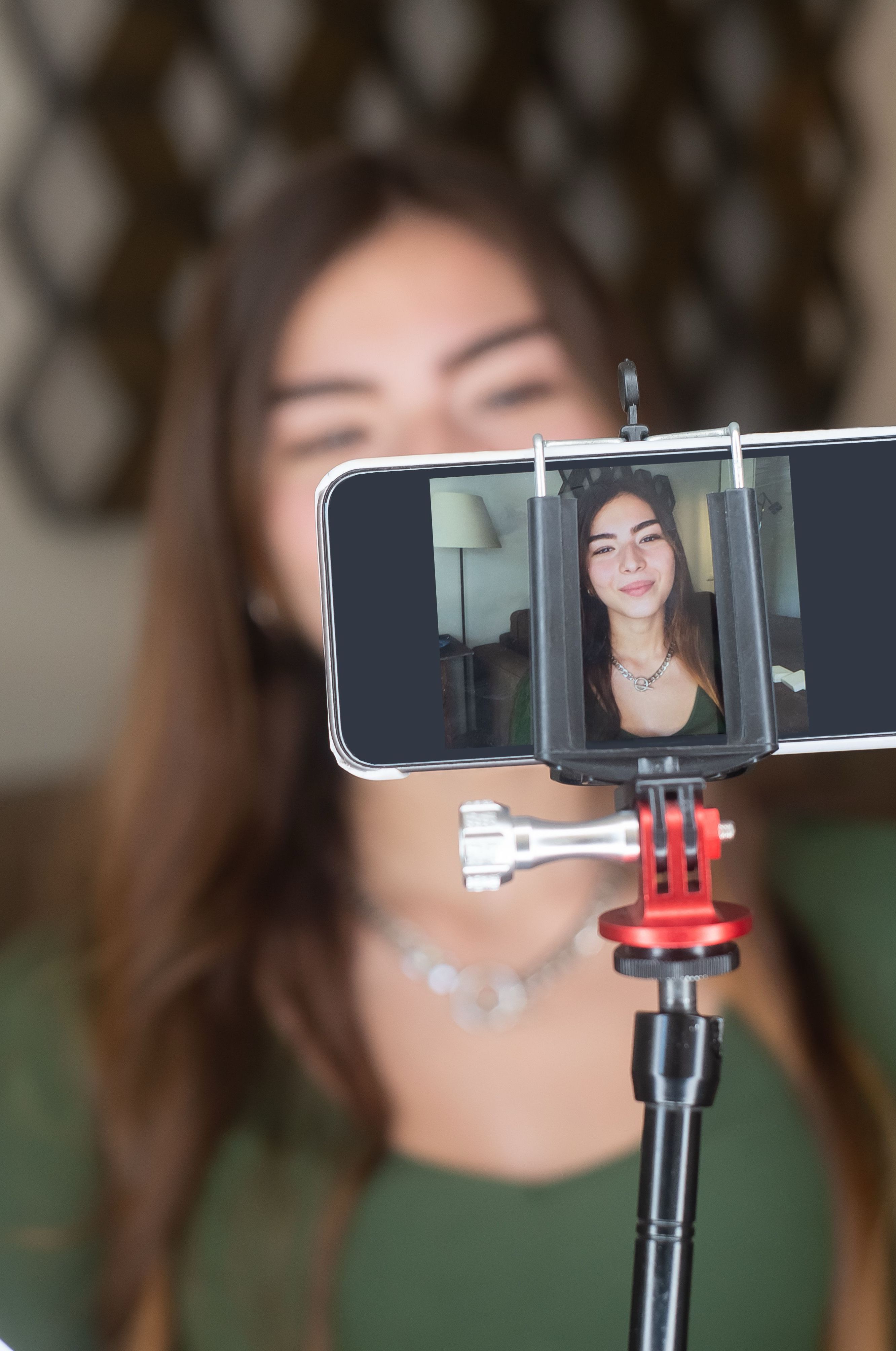 A creator filming content on a phone rig, focused on her work.